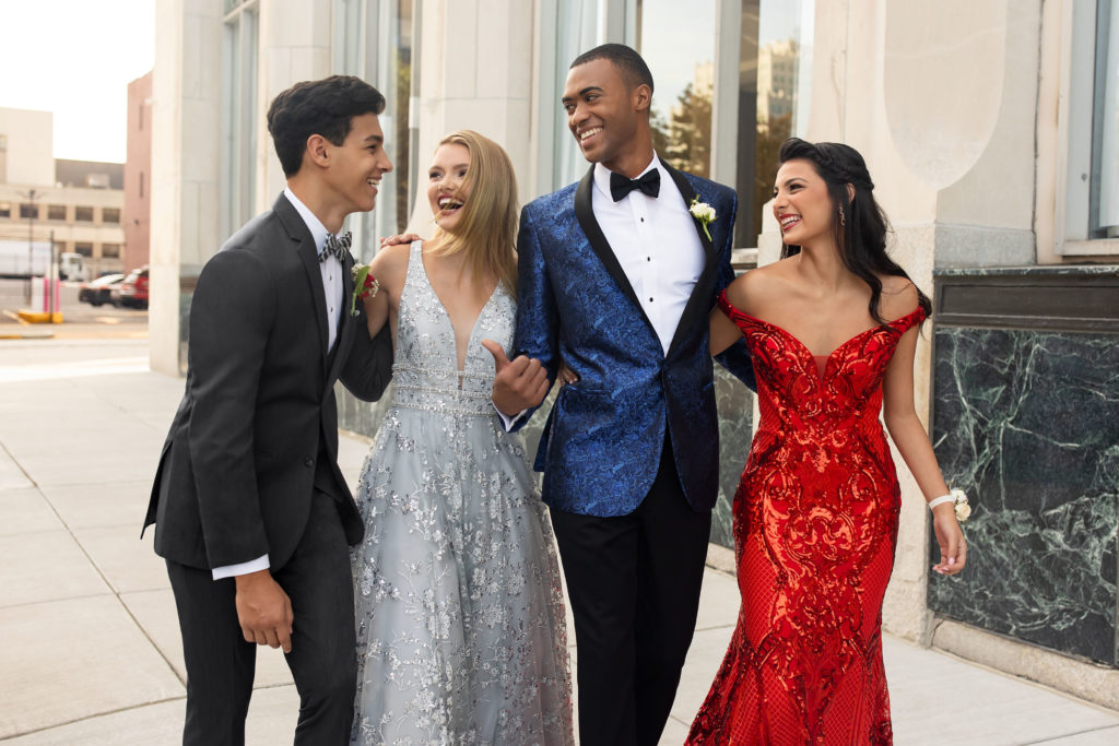 Two gorgeous wedding couples in elegant wedding suits, walking together and chatting happily